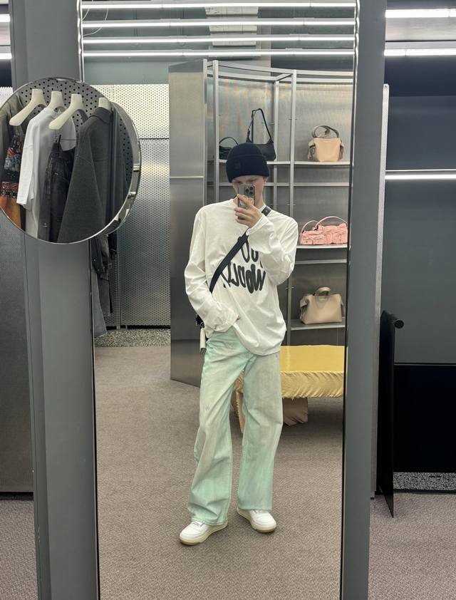 Model photo: Acne Studios' mint glow-in-the-dark wide-leg fluorescent jeans. Mad