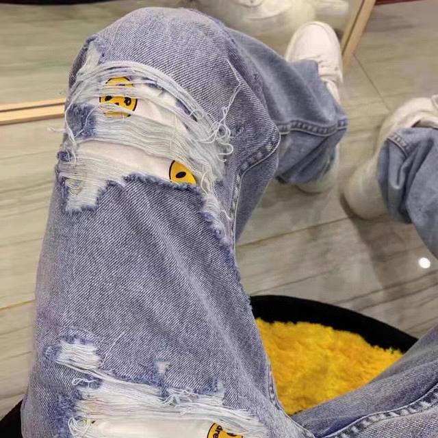 Drew House blue smiley face washed ripped straight-leg jeans, the same style as
