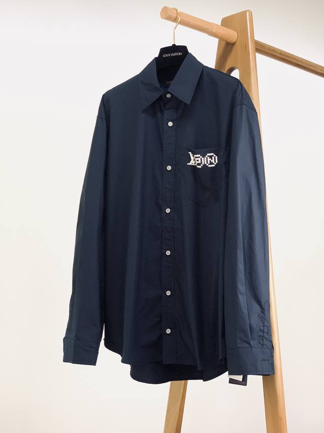 Louisvuitton 's head-printed shirt features a deep navy blue hue, creating a cal