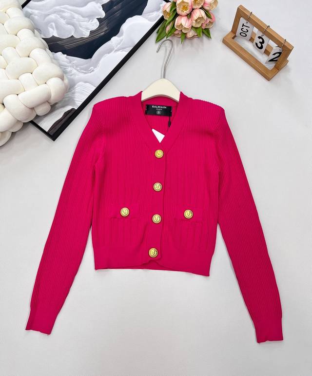 Balmain gold-buttoned V-neck knitted cardigan. The V-neck design modifies the fa