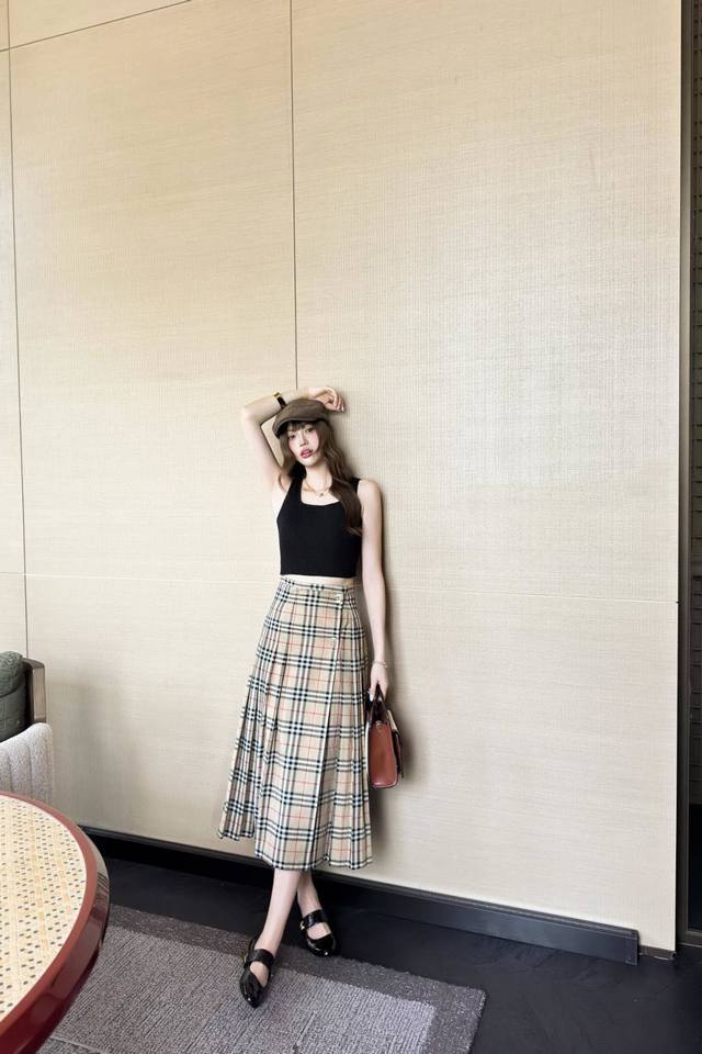 Burberr* Plaid pleated maxi skirt with one-piece hem and buckled sides. A slight