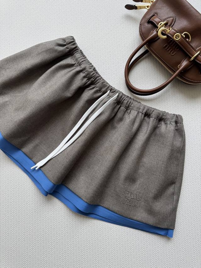 Miumi*25Fw's new early fall embroidered logo skirt with blue trim. Originally de