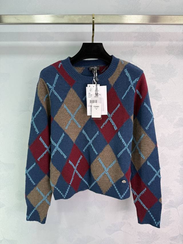 Ch*25A New diamond-patterned sweater in blue with contrasting red and brown. Thi