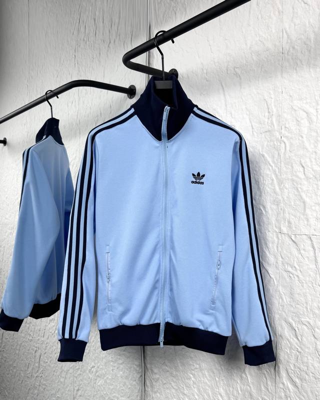 This Adidas jacket, featuring a three-bar, double-zipper embroidery pattern, is