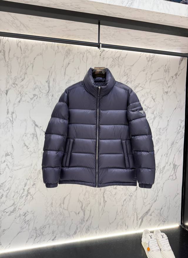 Prada's new jacquard nylon down jacket with a small metal logo. Made from recyc
