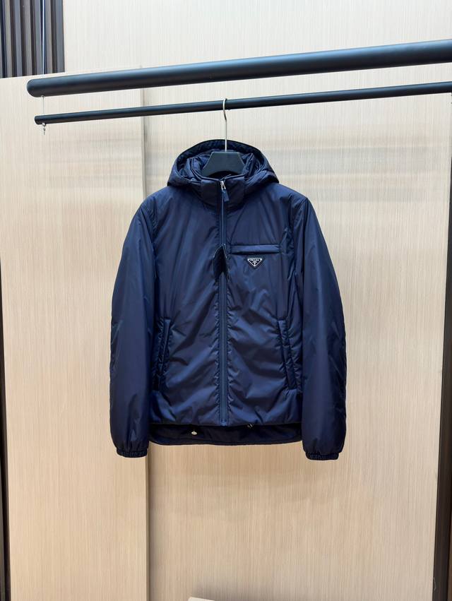 Prada's new jacquard nylon down jacket with a small metal logo. Made from recyc