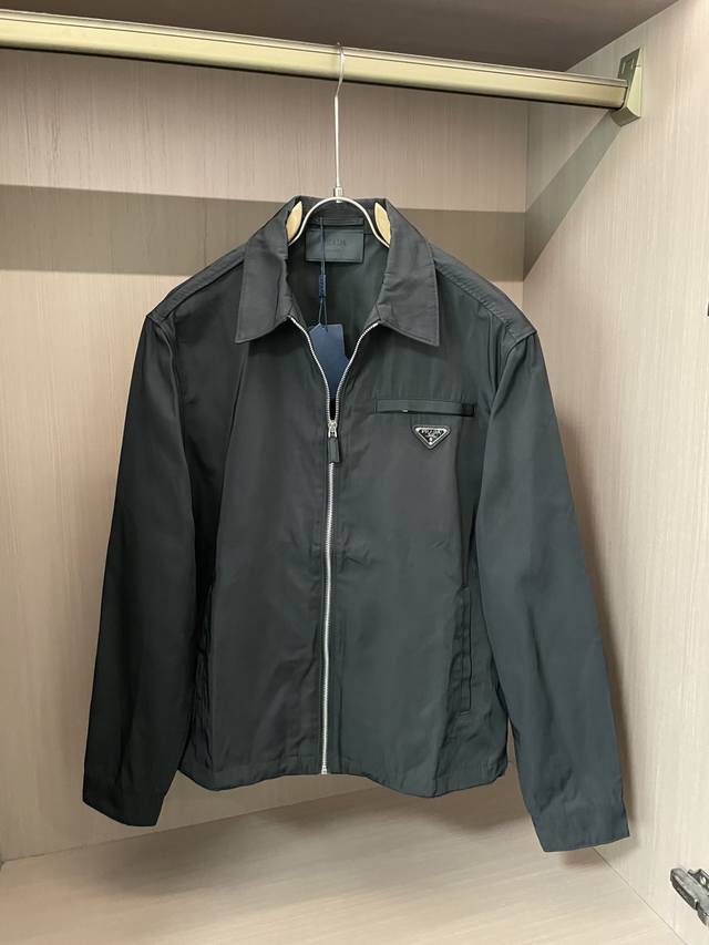 Prada men's casual jacket. Embellished with the iconic metal triangle logo, thi