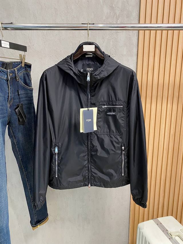 A windbreaker with a hood and side zipper pockets. Elasticated cuffs and a draw