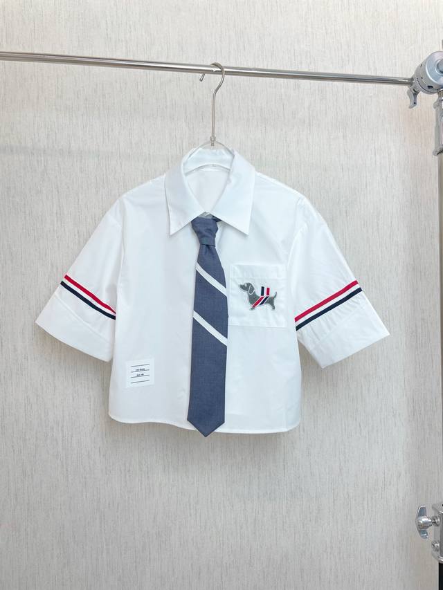 Tb A white short-sleeved shirt with a dark blue tie with white stripes. The cuff