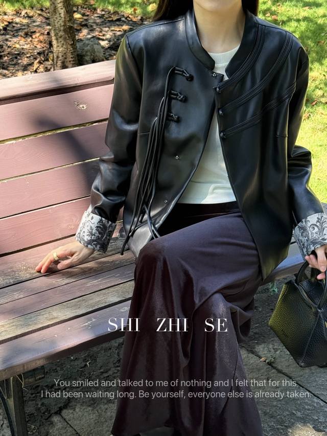 A Tang-style buttoned and tasseled protein leather jacket. The matte leather con