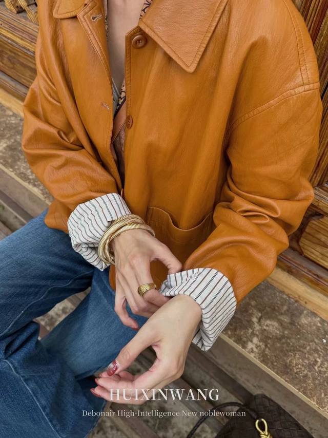 This elegant lapel-collared protein leather jacket boasts a refined, sophistica