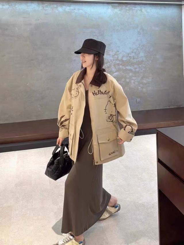 The same Hello Kitty trench coat as Mi Mi, in oatmeal khaki with a premium text