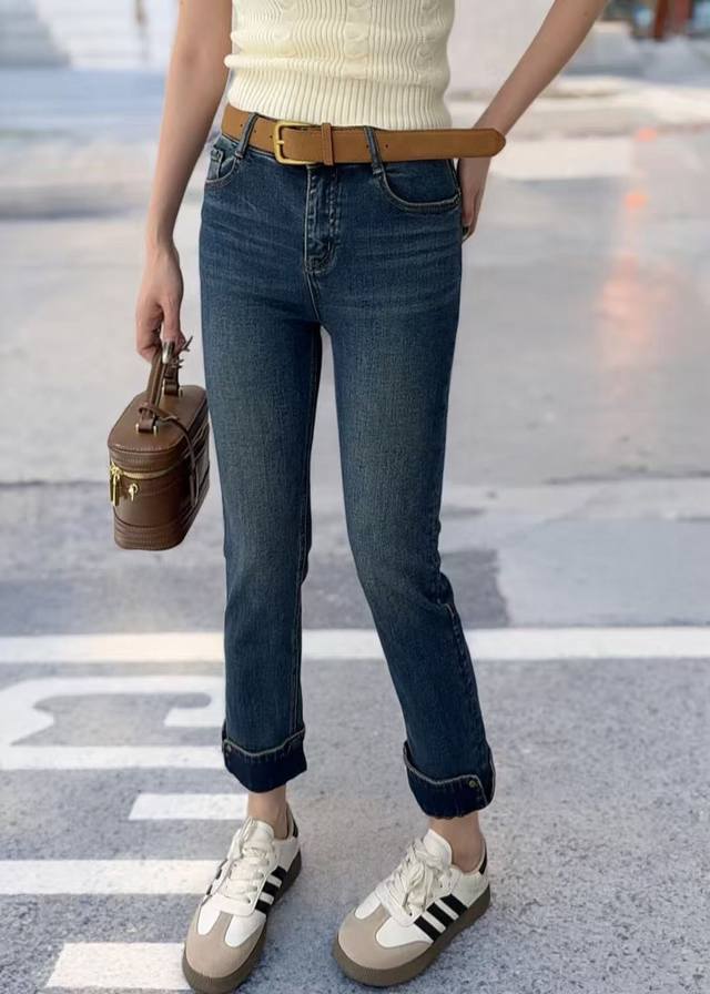 High-waisted skinny jeans visually lengthen the lower body and are paired with