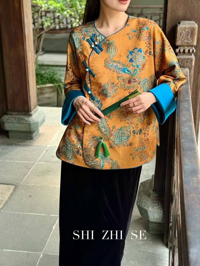 A silk blouse with golden threads and green silk buttons, featuring a warm gold