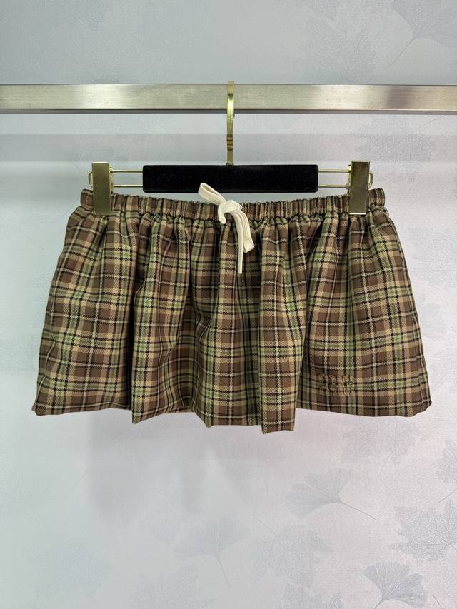 Miu*'s preppy, English-inspired skirt is custom-made with imported, yarn-dyed wo