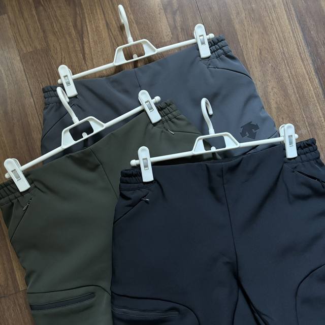 Descente Men's Fleece-Lined Woven Softshell Sports Pants. The woven fabric surfa
