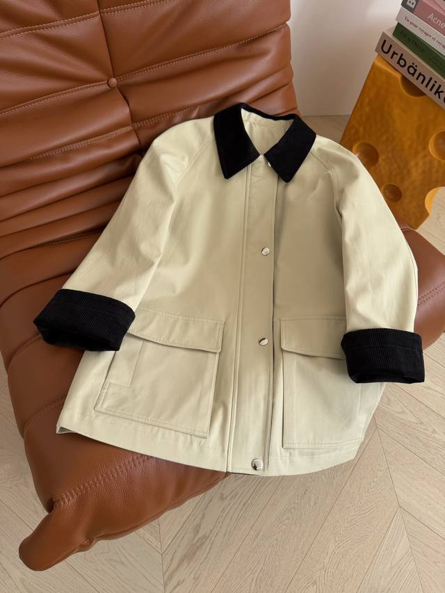 A retro-chic trench coat with a triangular logo design on the back. Features a c