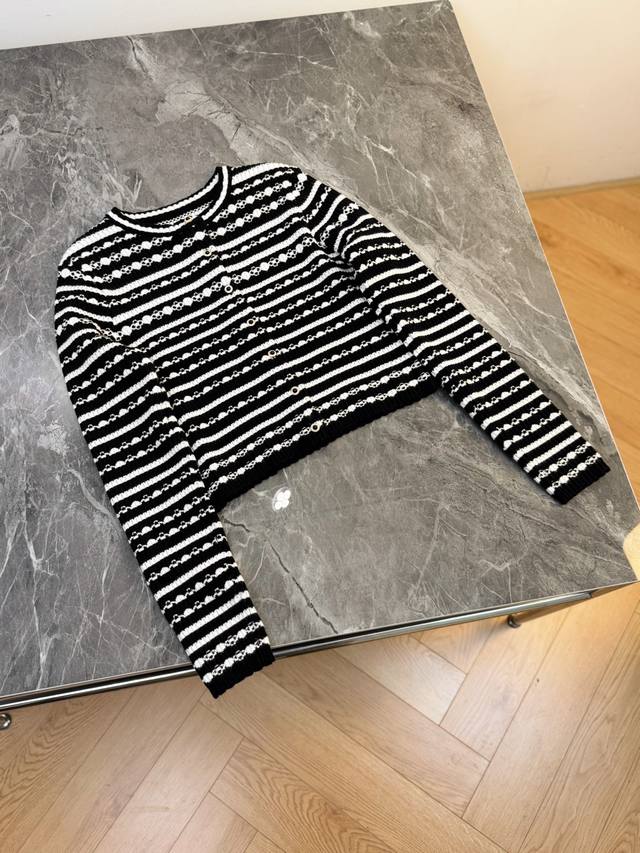 This black and white striped knit sweater is a clash of fashion and classic styl