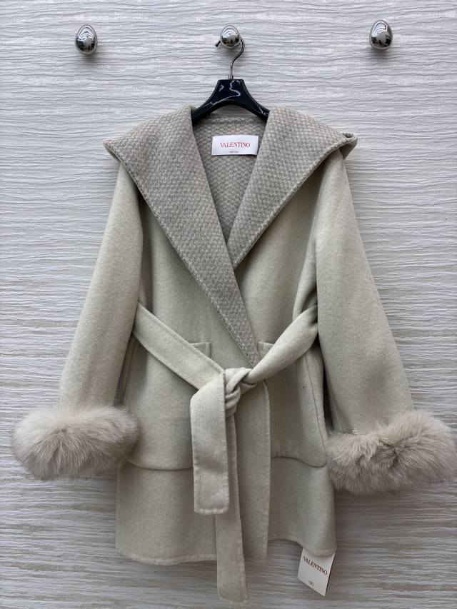 V-neck cashmere coat. The soft beige tone, paired with plush cuffs and a plaid l