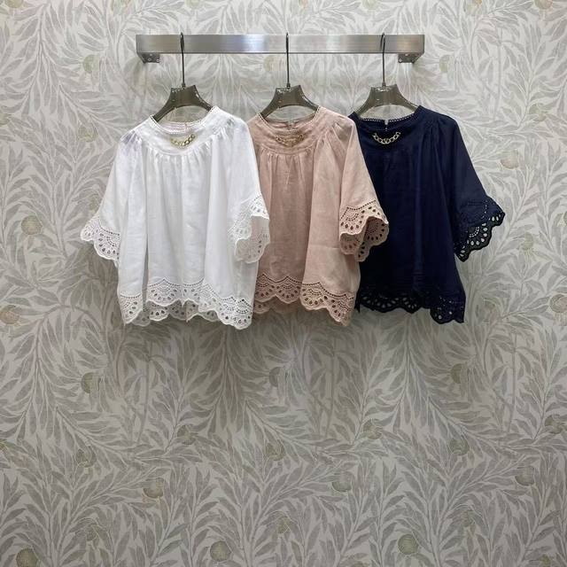 Va2026 Sp A white, pink, and navy blue blouse with a gold chain at the neckline