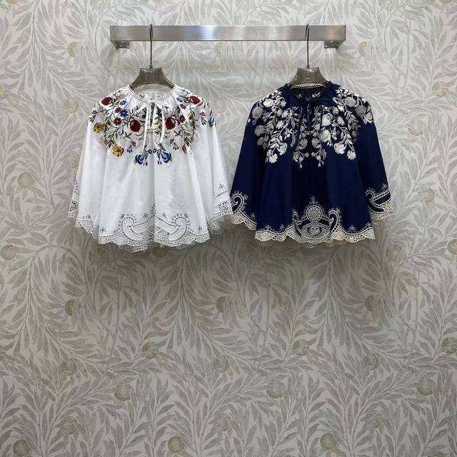 Va 2026 Sp A white and navy embroidered blouse, as if embroidering flowers and s